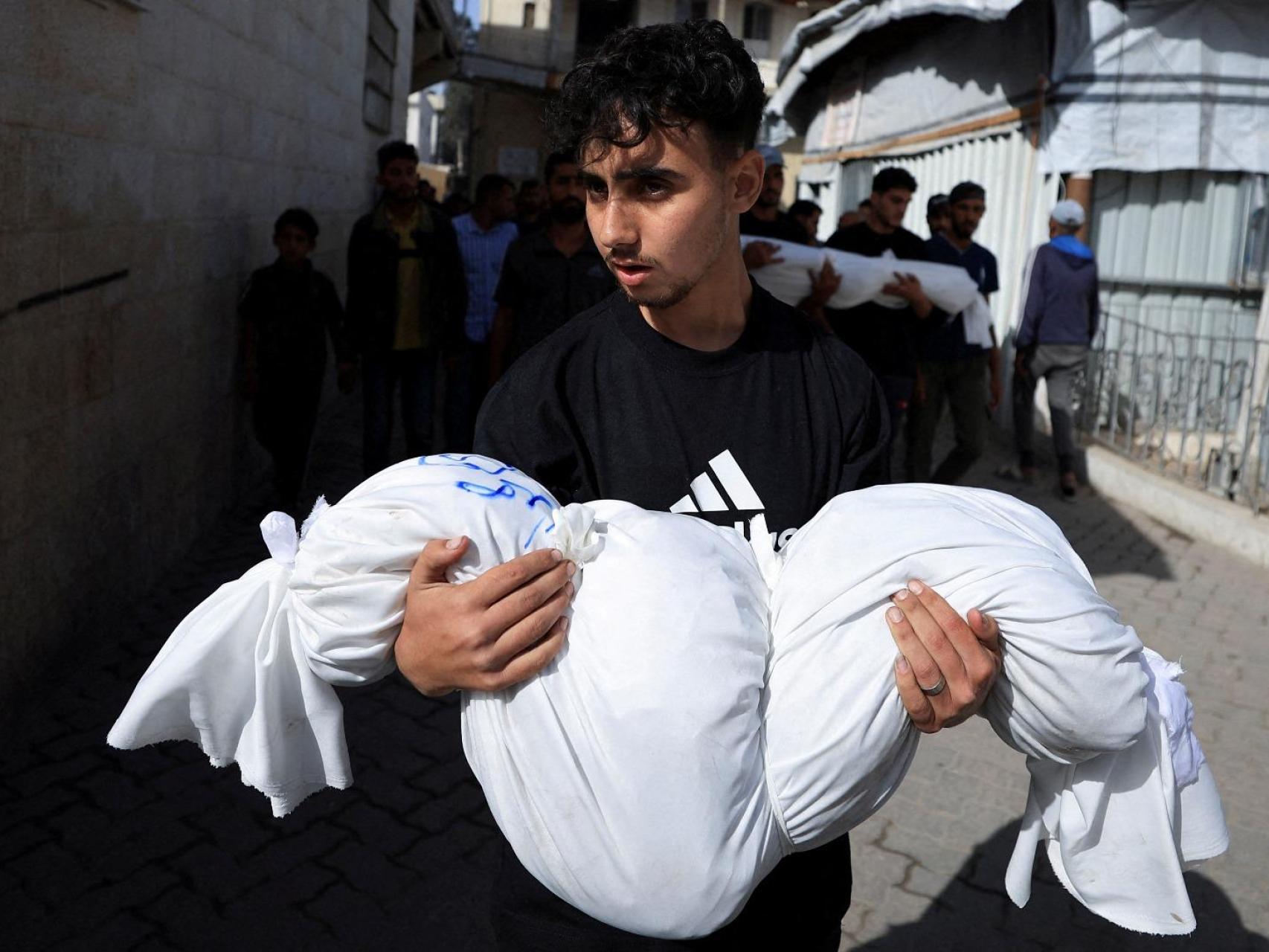 Un doliente sostiene un cuerpo durante el funeral de palestinos muertos en ataques israelíes, en el hospital bautista árabe Al-Ahli, en la Ciudad de Gaza, el 26 de mayo de 2025.