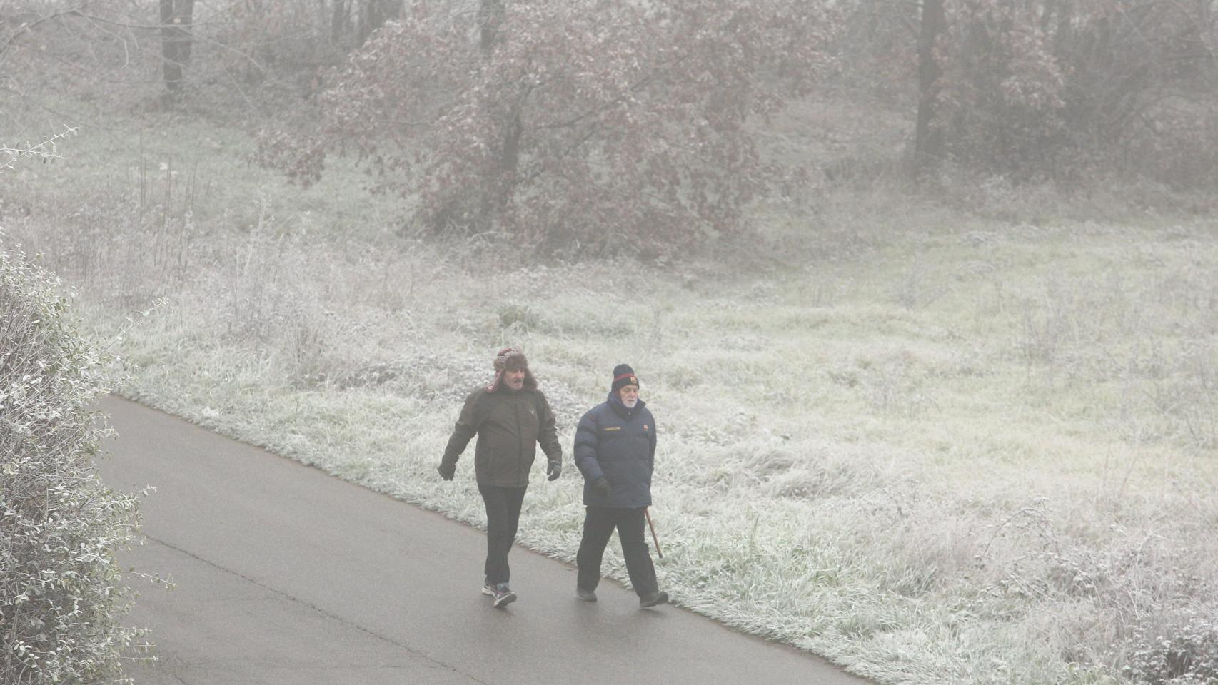 Dos personas paseando en un día de frío y niebla