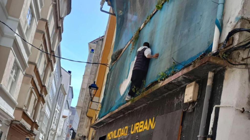 El okupa subido a la fachada.