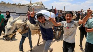 Palestinians carry aid supplies they received from the US-backed Gaza Humanitarian Foundation in Khan Yunis, southern Gaza Strip, on May 28, 2025.
