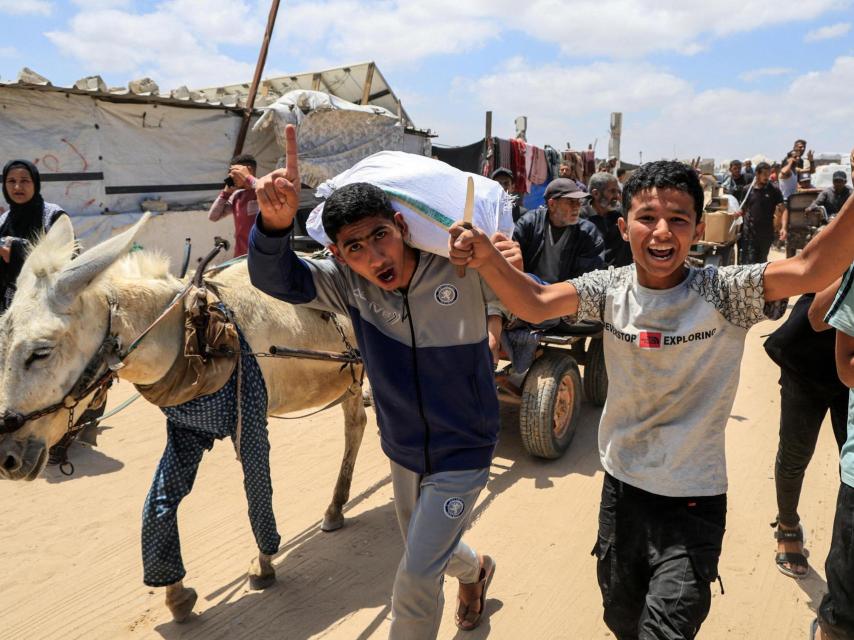 Los palestinos cargan suministros de ayuda que recibieron de la Fundación Humanitaria para Gaza, respaldada por Estados Unidos, en Jan Yunis, en el sur de la Franja de Gaza, el 28 de mayo de 2025.