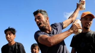 Una persona sostiene alimentos mientras los palestinos se reúnen cerca de un centro de distribución de ayuda dirigido por la Fundación Humanitaria de Gaza en el sur de la Franja de Gaza, el 27 de mayo de 2025.