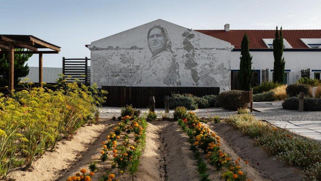 El huerto del hotel y, en el fondo, el mural del artista portugués Vhils.