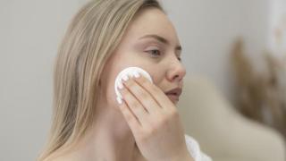 Imagen ilustrativa de una mujer desmaquillándose.