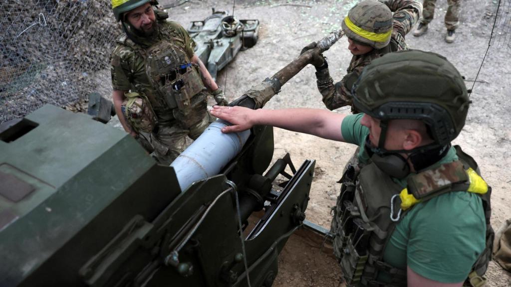 Soldados ucranianos cargan munición en un obús mientras disparan contra tropas rusas en una posición en una línea de frente cerca de la ciudad de Kupiansk, en la región de Járkov (Ucrania)