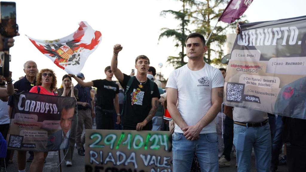 Un grupo de manifestantes sostienen pancartas en contra de Pedro Sánchez frente al cordón policial en Moncloa.