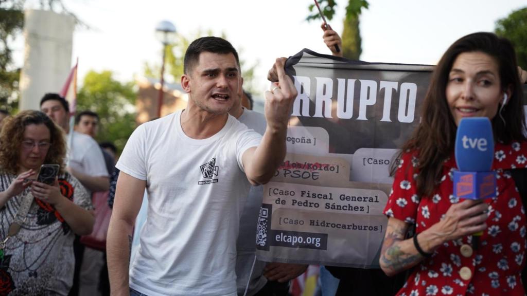 Un asistente hace una peineta a la cámara durante una conexión en directo de Televisión Española.