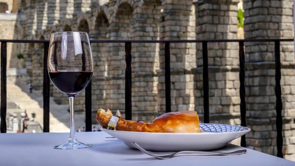 Un plato de cochinillo de Mesón de Cándido con vistas al acueducto de Segovia.