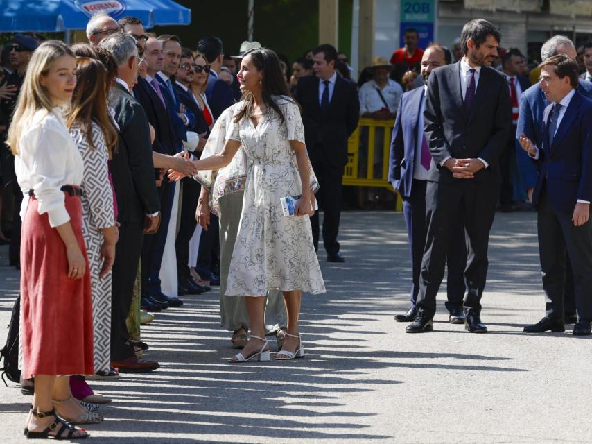 La reina Letizia saluda mientras el alcalde de Madrid, José Luis Martínez Almeida conversa con el ministro de Cultura, Ernest Urtasun en la inauguración de la Feria del Libro de Madrid este viernes