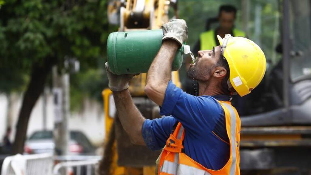 Un trabajador de la construcción bebe agua durante su jornada laboral.