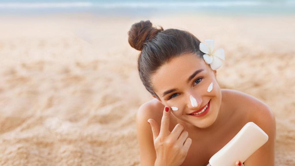 Una joven se aplica protector solar sobre el rostro