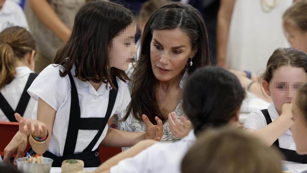 La reina Letizia, en un taller para niños, durante su visita a las casetas de la Feria del Libro de Madrid este viernes en la inauguración de su 84.ª edición. Foto: EFE/JJ Guillén