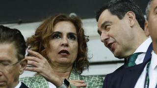 La vicepresidenta del Gobierno, María Jesús Montero, junto al presidente de la Junta, Juanma Moreno, en el partido del Betis en Polonia.