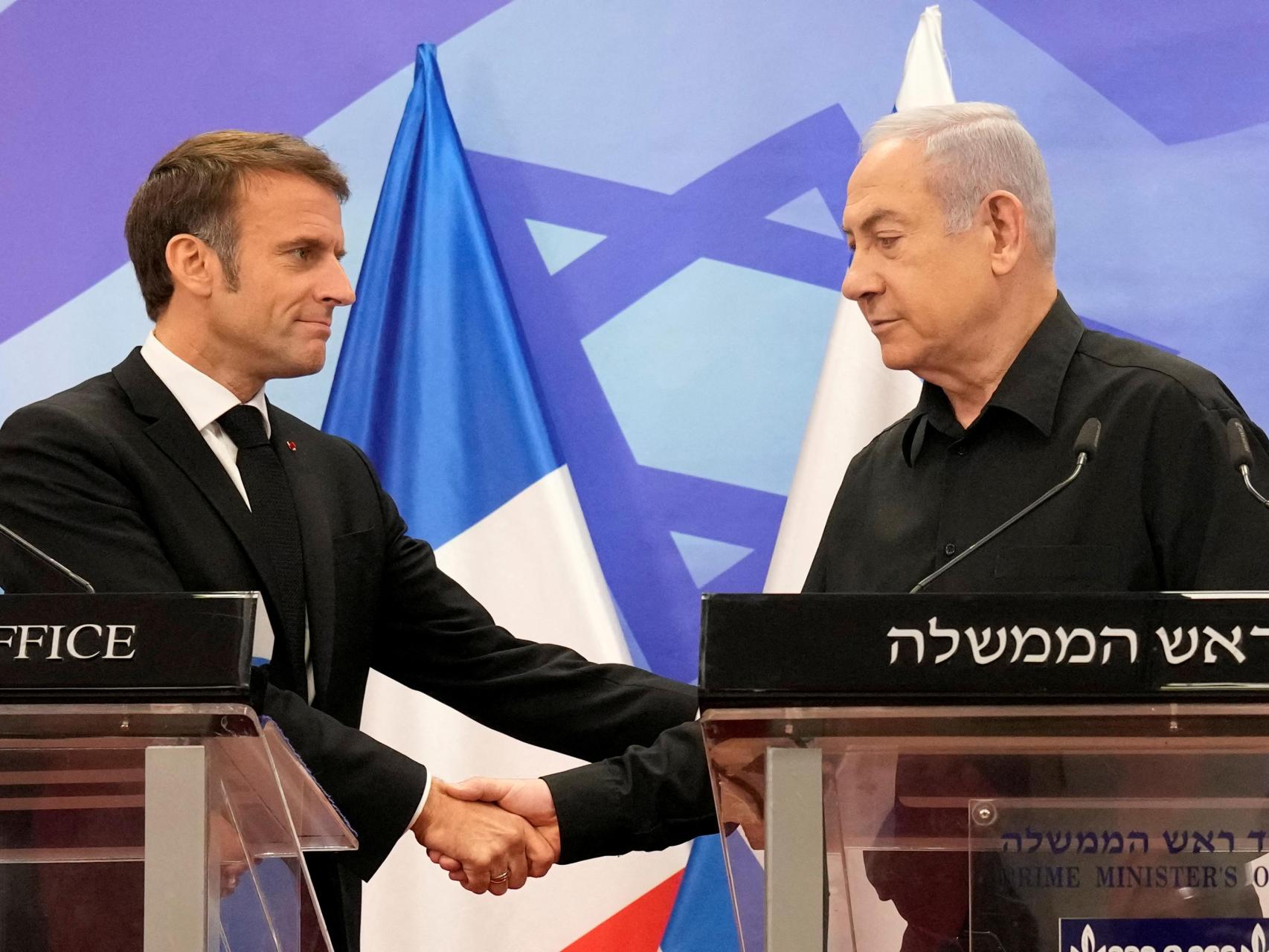 El primer ministro israelí, Benjamin Netanyahu, estrecha la mano del presidente francés, Emmanuel Macron, durante una conferencia de prensa conjunta en Jerusalén, el 24 de octubre de 2023.