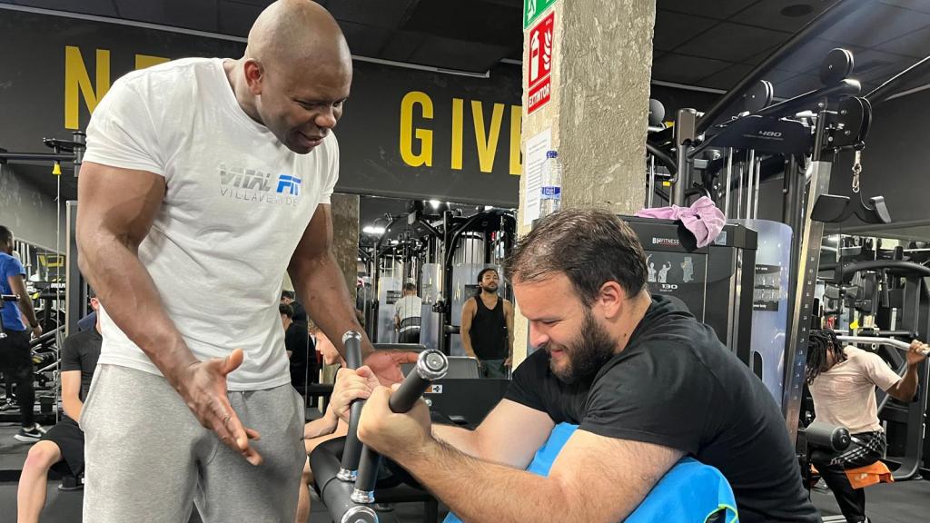 Zola Da Costa aconseja a un deportista en el gimnasio.