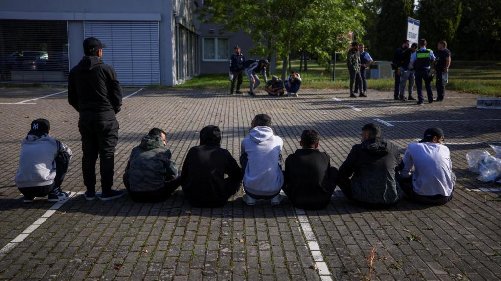 Presuntos inmigrantes ilegales se sientan en el suelo después de ser detenidos por la policía alemana durante su patrullaje a lo largo de la frontera germano-polaca para prevenir la migración ilegal, en Forst, Alemania, el 20 de septiembre de 2023