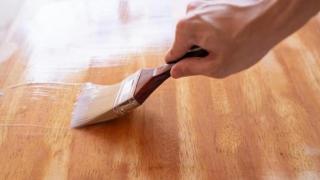 Persona aplicando barniz.