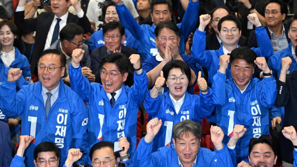 Miembros del Partido Democrático de Corea reaccionan mientras miran un reportaje televisivo sobre una encuesta a boca de urna para las elecciones presidenciales de Corea del Sur en la sala de situación del partido en la Asamblea Nacional en Seúl, Corea del Sur