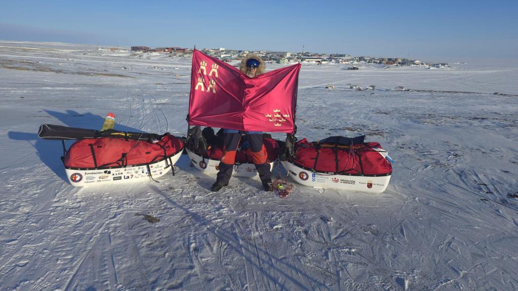 El explorador Quitín Mira extiende la bandera de la Región de Murcia tras completado la expedición.