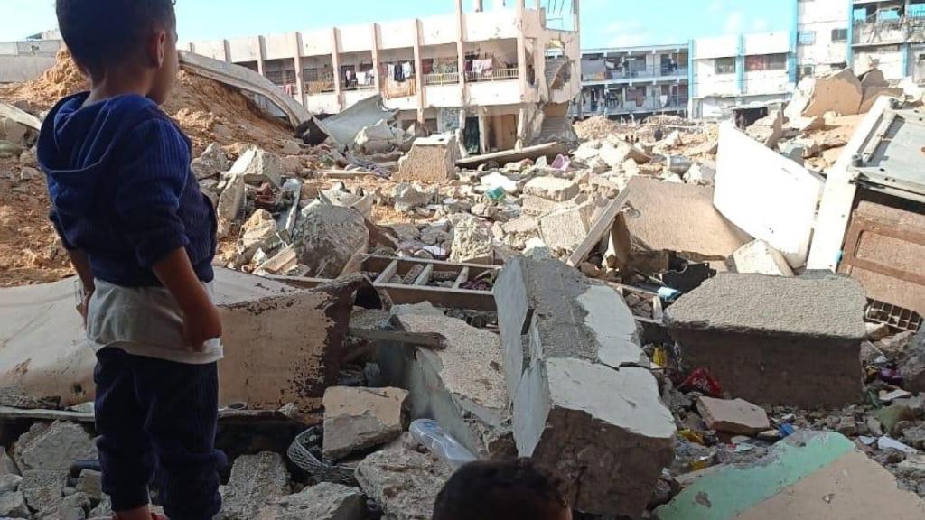 Un sobrino de Ahmed rodeado de edificios destruidos.