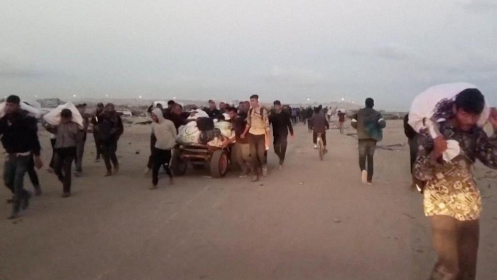 Palestinos llevan los paquetes de ayuda recibidos en Rafah.