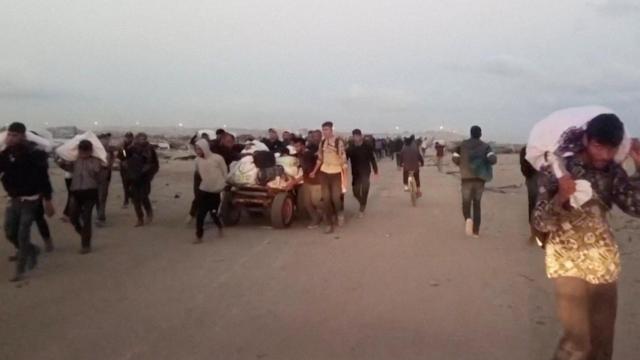 Palestinos llevan los paquetes de ayuda recibidos en Rafah.