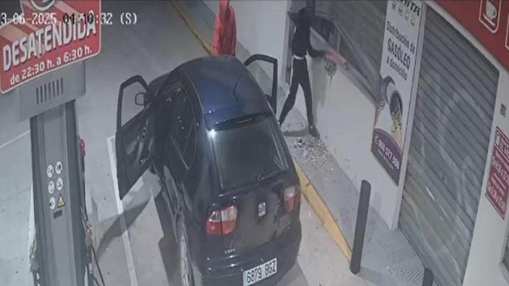 Los dos encapuchados, durante la madrugada de este miércoles, dándole martillazos a la persiana metálica de la Gasolinera de La Hita del Mar Menor.