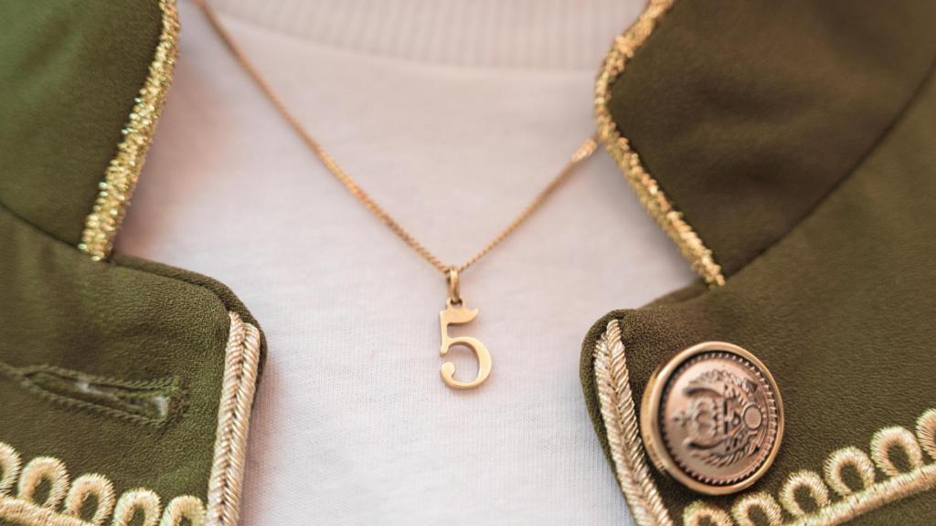 Detalle del número 5 que Nieves lleva colgado al cuello para recordar su segunda fecha de nacimiento: el 5 de febrero de 2025.
