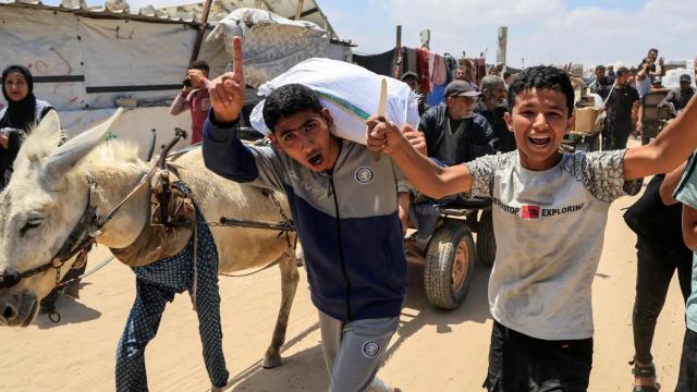 Palestinos cargan con suministros de ayuda de la Fundación Humanitaria para Gaza, respaldada por Estados Unidos.