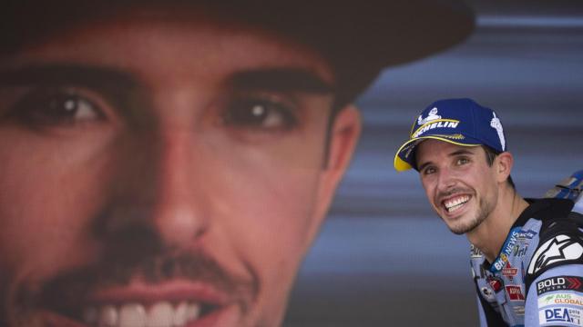 Álex Márquez, con su imagen proyectada en una pantalla gigante en un podio de MotoGP.