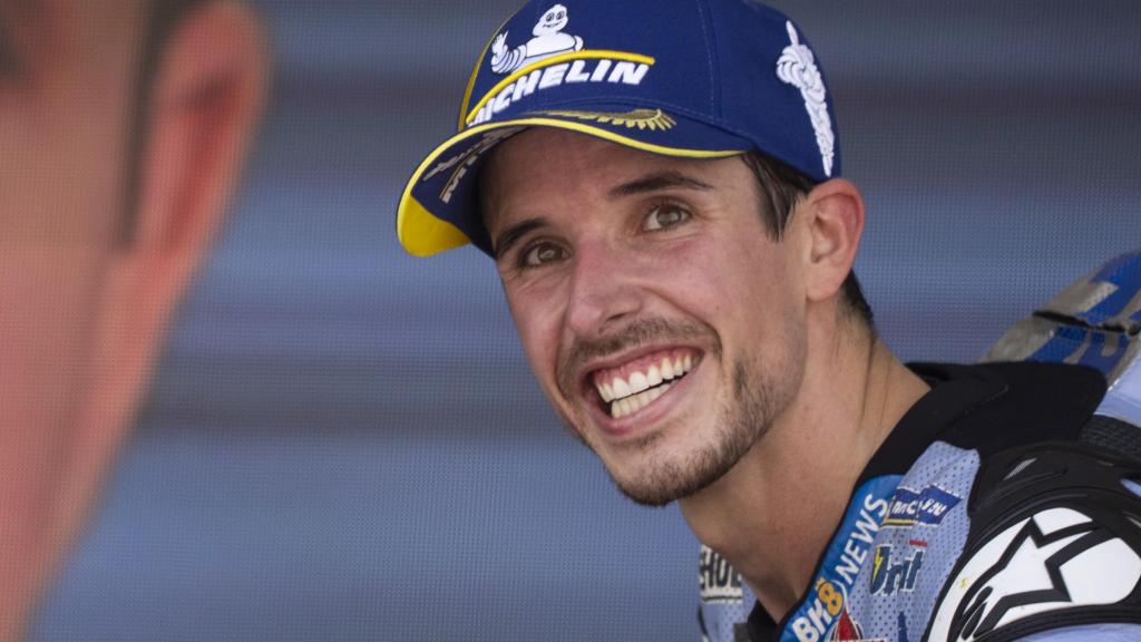 Álex Márquez, con su imagen proyectada en una pantalla gigante en un podio de MotoGP.