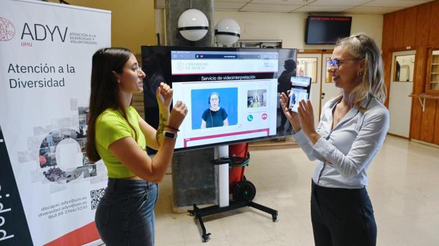 Una alumna de la Universidad de Murcia y una técnica se comunican por lengua de signos.
