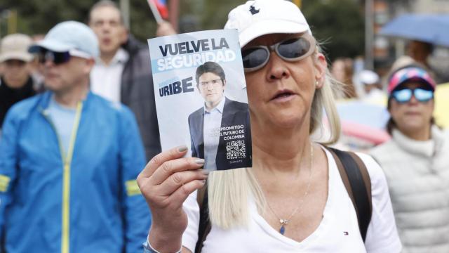 Una mujer sostiene un cartel durante una caminata por la paz y en apoyo al senador Miguel Uribe Turbay este domingo en Bogotá.