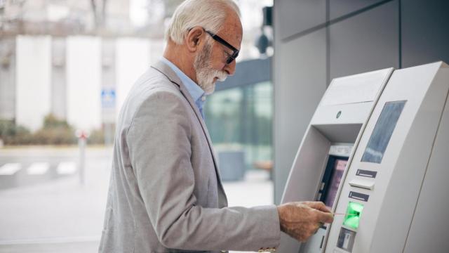 Un jubilado retira efectivo en un cajero automático.