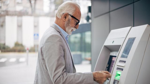 Un jubilado retira efectivo en un cajero automático.