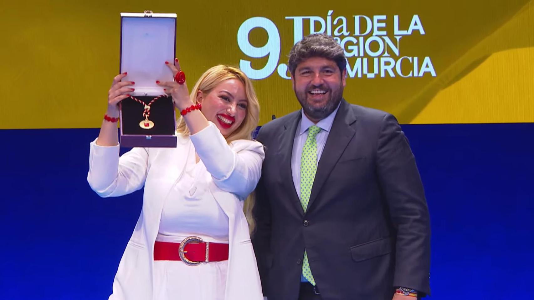 La directora territorial de la Fundación Secretariado Gitano, Sara Cortés, recoge la medalla de Oro de la Región de Murcia de manos de Fernando López Miras.