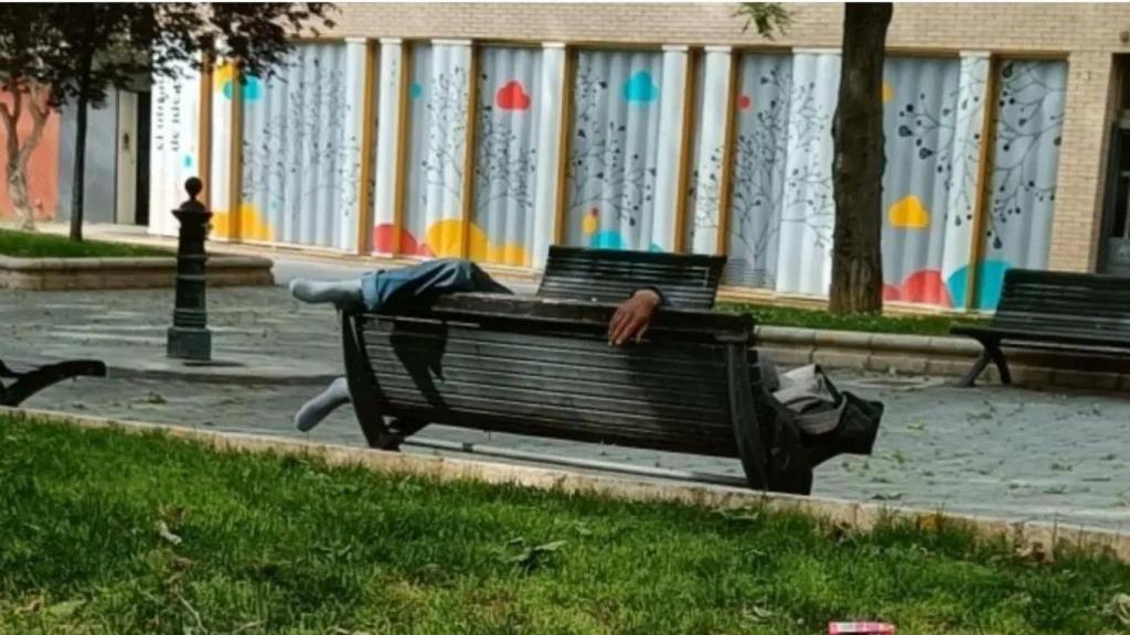 Un hombre durmiendo en un banco de la zona