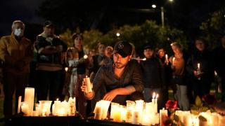 Personas colocan velas en el lugar donde el senador colombiano Miguel Uribe Turbay fue baleado durante un acto de campaña, en Bogotá.