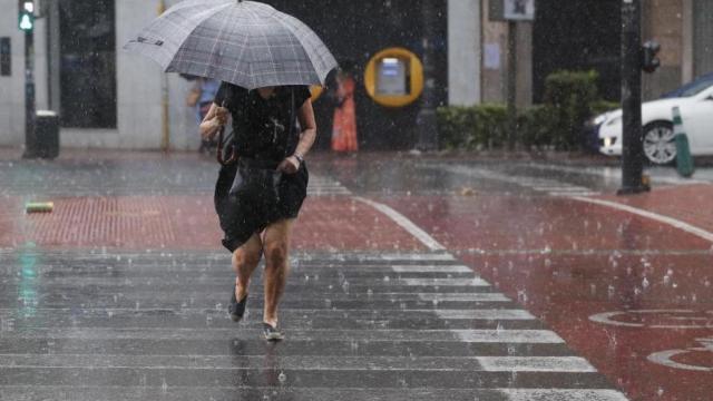 Una mujer se protege de una tormenta de verano.