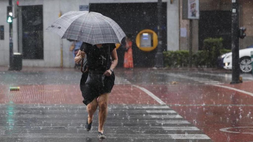 Una mujer se protege de una tormenta de verano.
