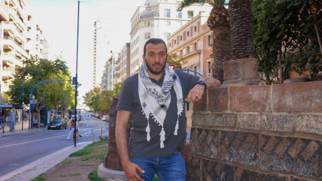 Ahmed posa con un pañuelo palestino en la Rambla de Alicante.