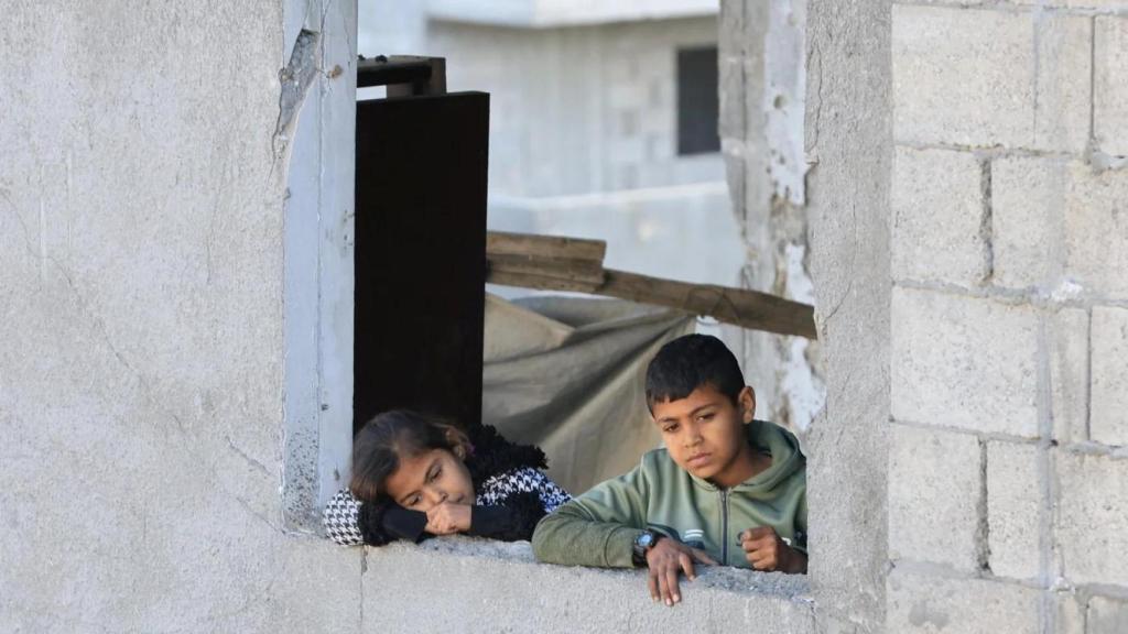Niños palestinos observan el lugar de un ataque israelí contra un edificio residencial en la Ciudad de Gaza el 19 de marzo de 2025.