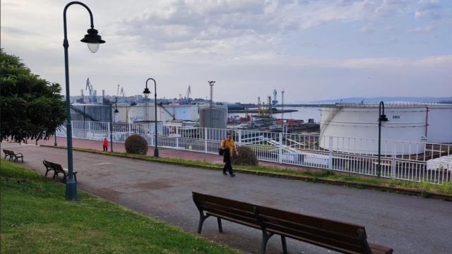 Vecinos pasean en el parque de San Diego de A Coruña, con el muelle del mismo nombre al fondo.
