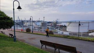 Vecinos pasean en el parque de San Diego de A Coruña, con el muelle del mismo nombre al fondo.