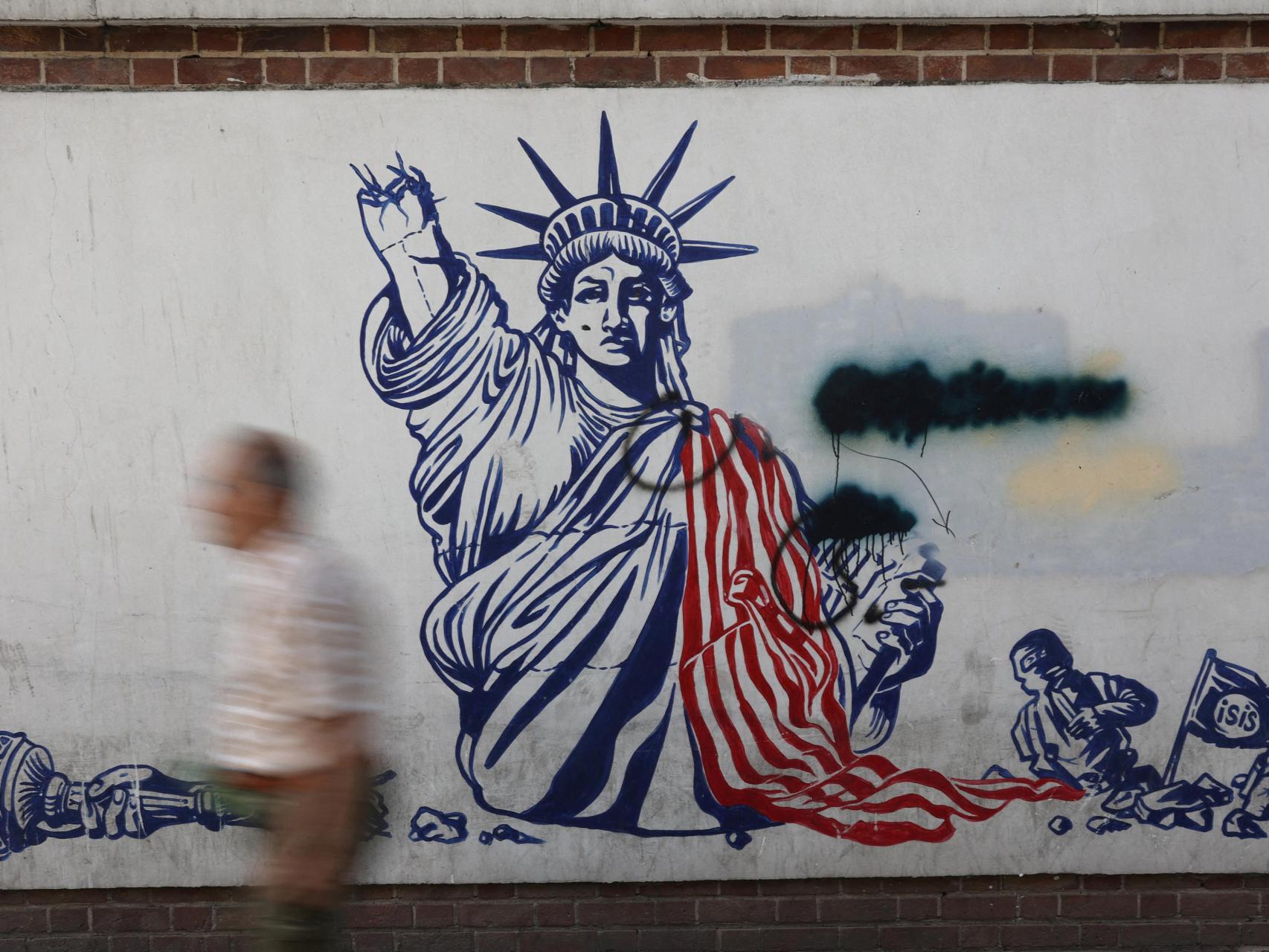Un hombre pasa junto a un mural antiestadounidense en una calle de Teherán.