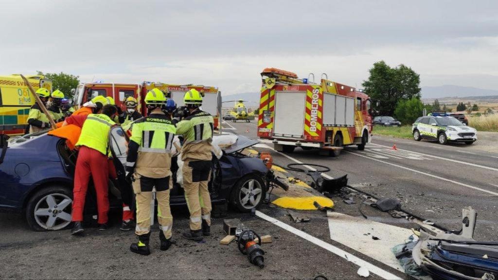 Imagen de los bomberos y equipo sanitario trabajando en la zona del accidente, en la A-1213