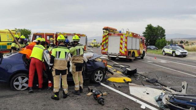 Imagen de los bomberos y equipo sanitario trabajando en la zona del accidente, en la A-1213