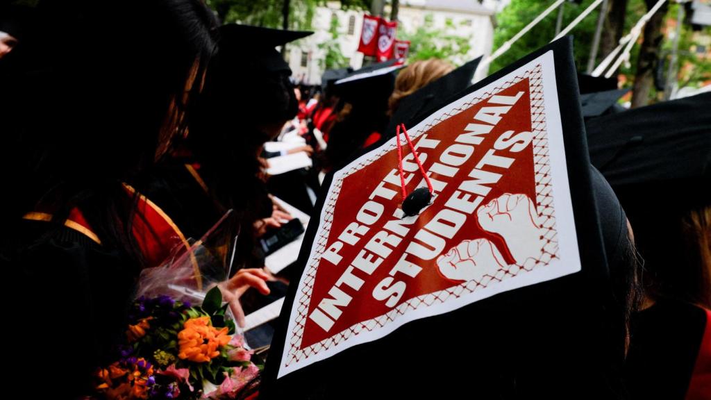 Un estudiante graduado usa su birrete, decorado con una declaración de apoyo a los estudiantes internacionales en la Universidad de Harvard en Cambridge, Massachusetts, EEUU.