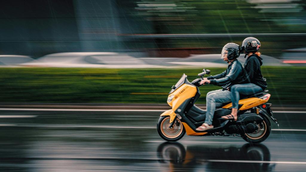 Dos personas montando en una motocicleta mientras llueve