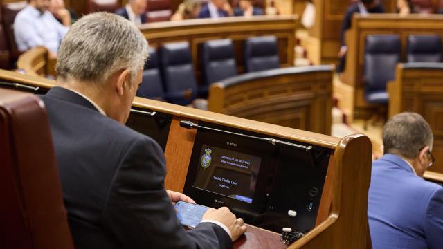 Santos Cerdán, este jueves en su escaño, buscando su propio nombre en el informe de la UCO que le incrimina.
